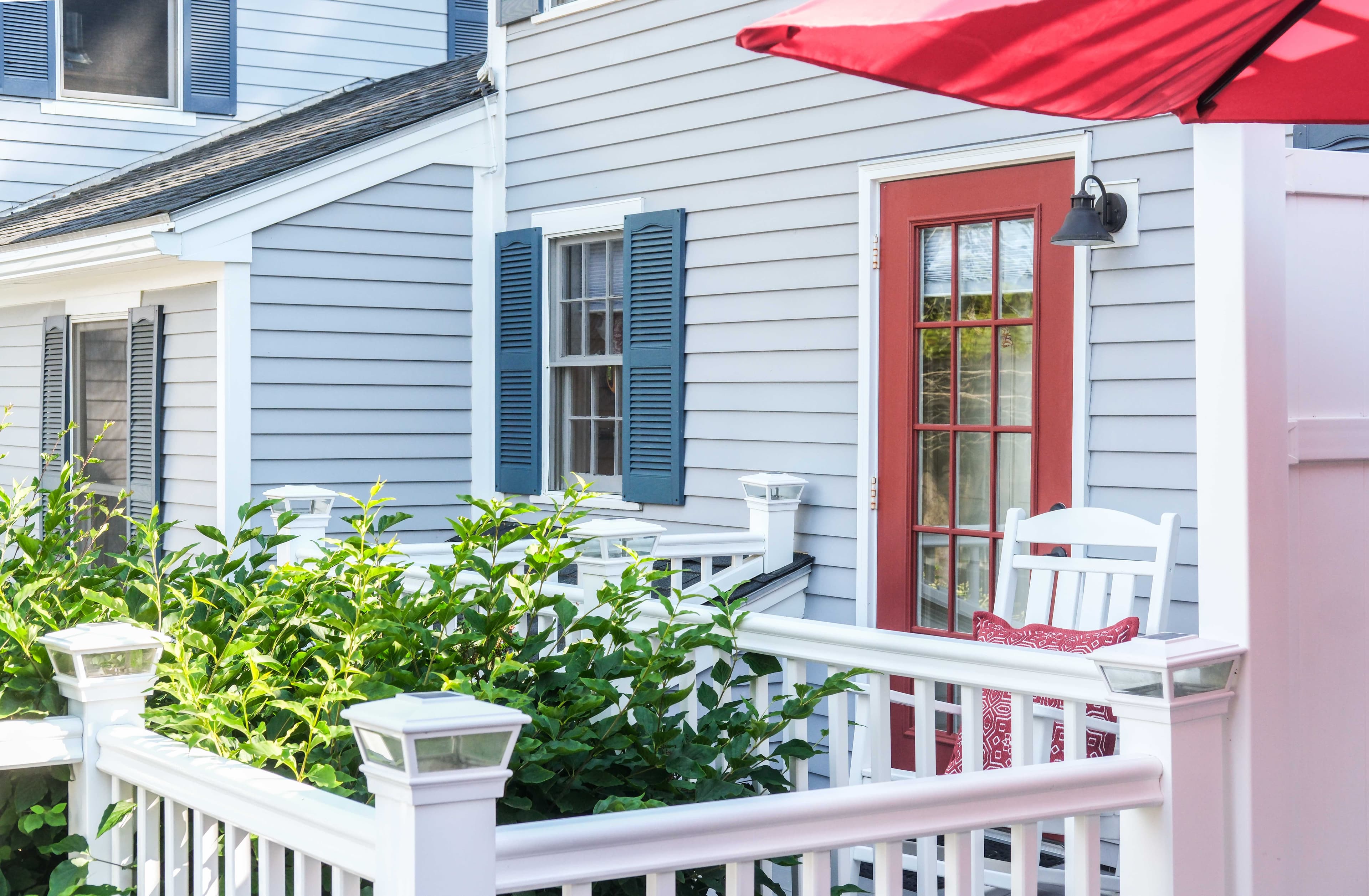 Private outdoor balcony with two rocking chairs and table.