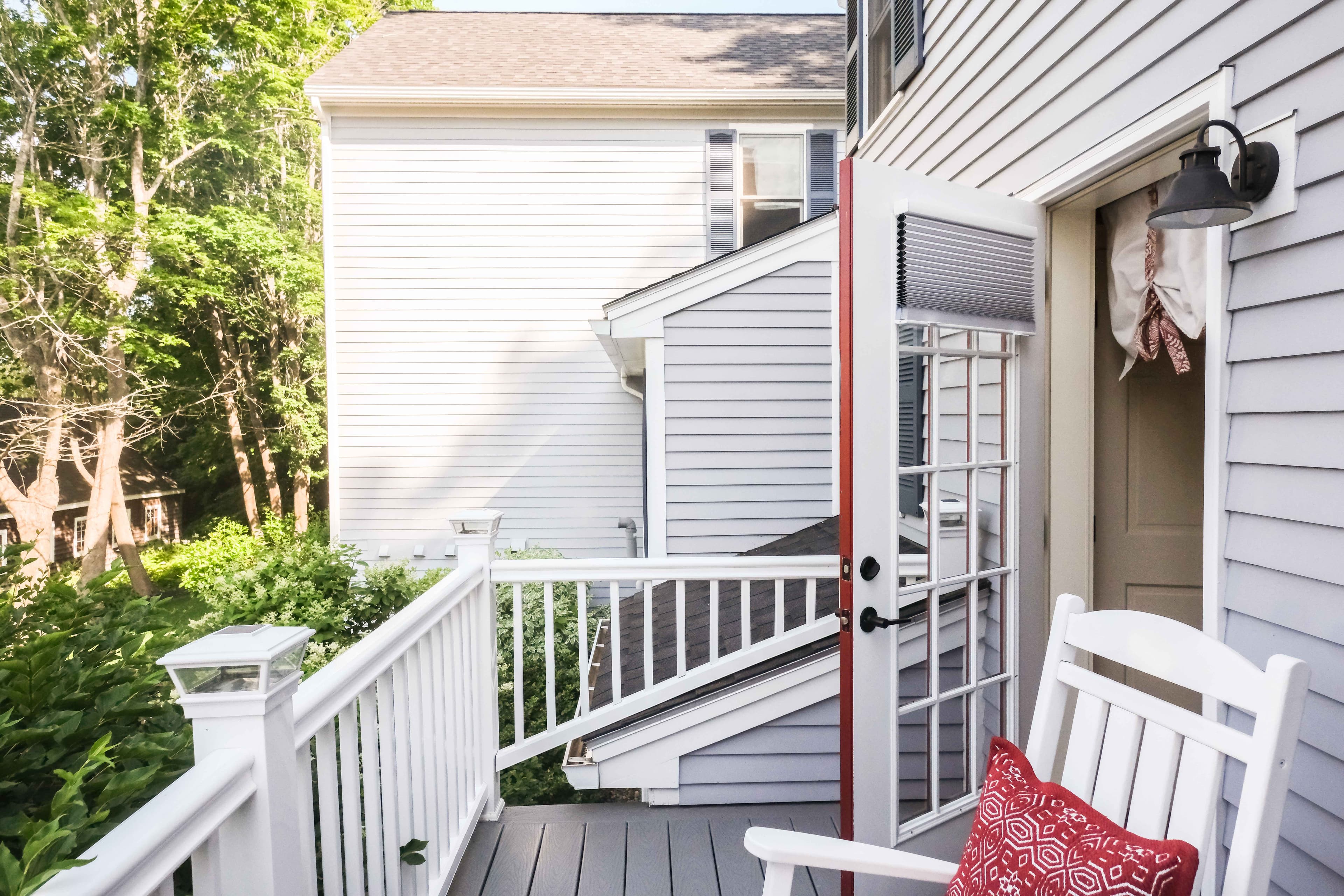 Private outdoor balcony with two rocking chairs and table.