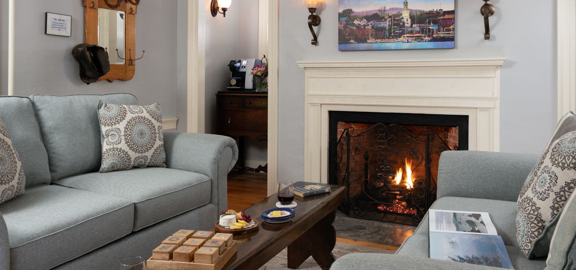 A cozy living room with two sofas, a coffee table, and a lit fireplace.