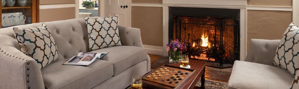Cozy living room with a fireplace, two sofas, and a coffee table with a checkerboard game.