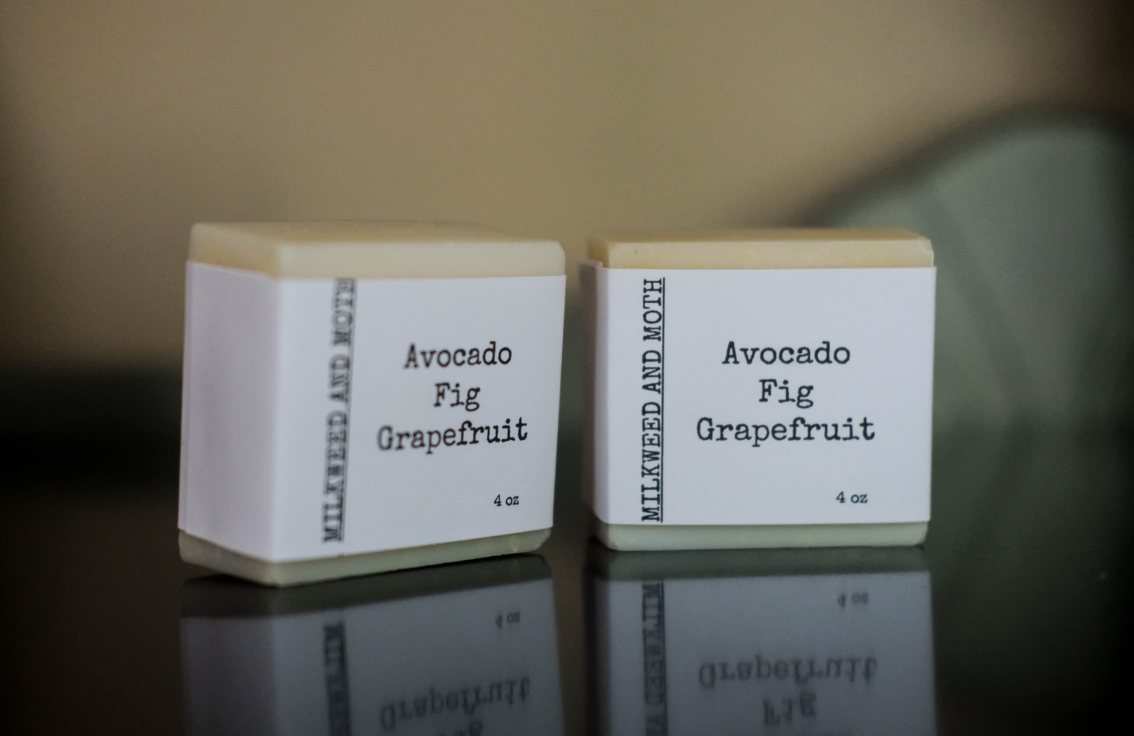 Two bars of soap labeled "Avocado Fig Grapefruit" with a white and black design.