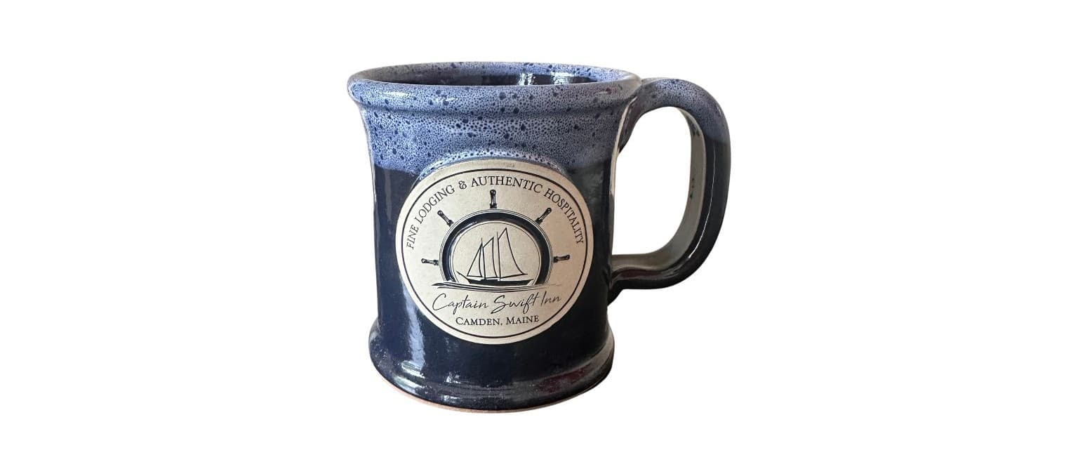 Ceramic mug with a blue glaze featuring a nautical-themed logo.